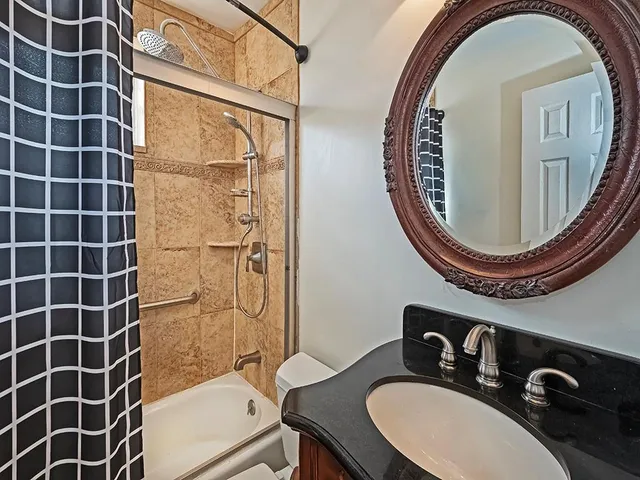 a bathroom with a sink mirror toilet and shower