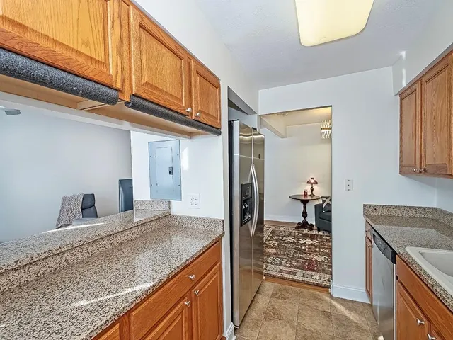 a kitchen with granite countertop cabinets and entryway