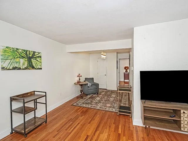 a living room with a flat screen tv and a rug
