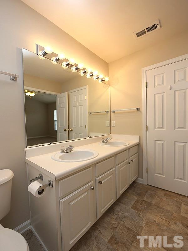 8519 Silhouette Place Raleigh, NC 27613 - Photo 11 of 19 a bathroom with a double vanity sink and mirror