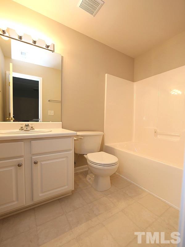 8519 Silhouette Place Raleigh, NC 27613 - Photo 16 of 19 a bathroom with a toilet a sink and mirror