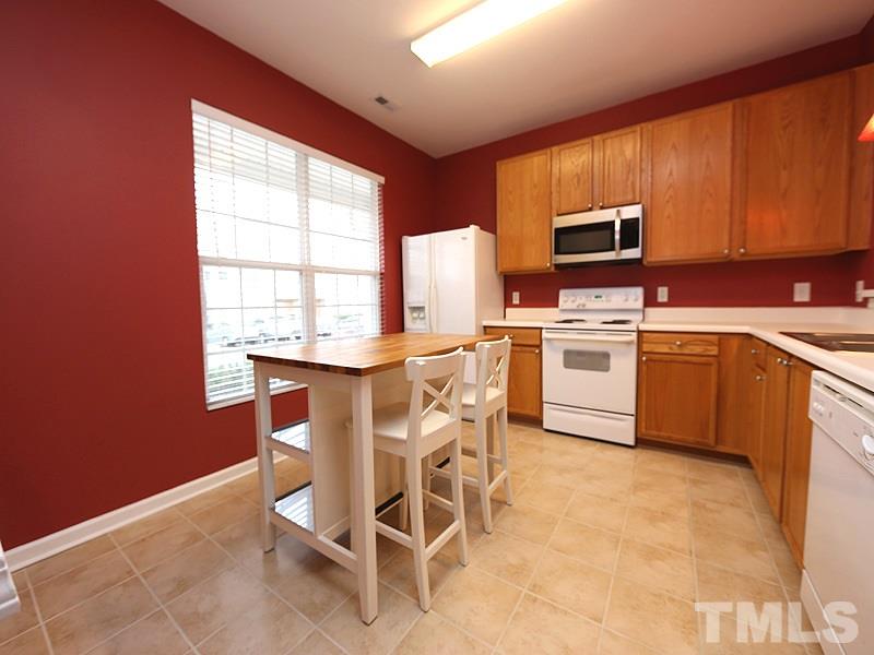 8519 Silhouette Place Raleigh, NC 27613 - Photo 3 of 19 a kitchen with stainless steel appliances a stove a sink refrigerator and microwave