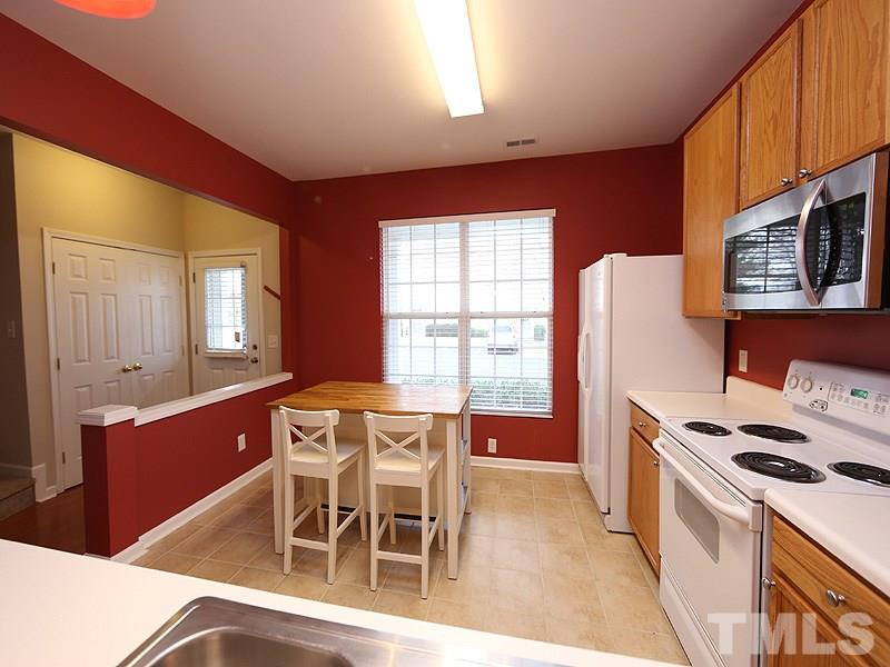 8519 Silhouette Place Raleigh, NC 27613 - Photo 4 of 19 a dining room with furniture a window and a kitchen view