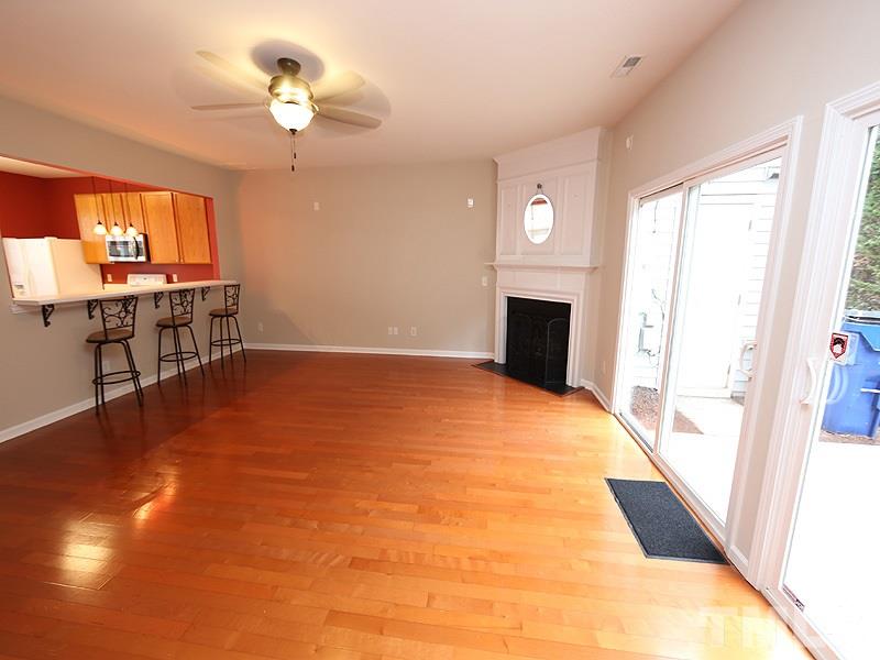 8519 Silhouette Place Raleigh, NC 27613 - Photo 7 of 19 a view of empty room with a fireplace and wooden floor