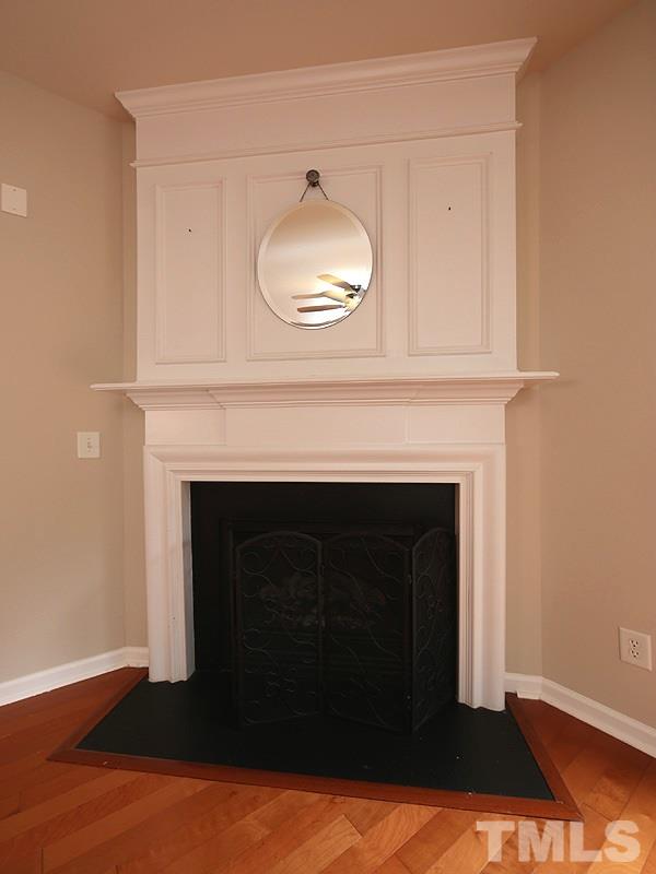 8519 Silhouette Place Raleigh, NC 27613 - Photo 8 of 19 a living room with a fireplace and a wooden floor