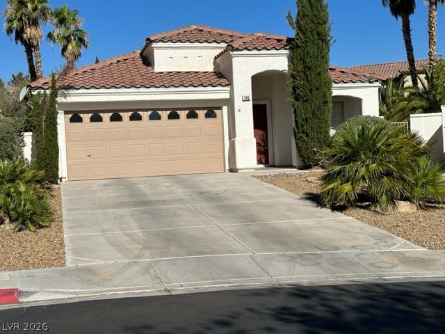 Mediterranean / spanish home featuring a garage, stucco siding, concrete driveway, and a tiled roof