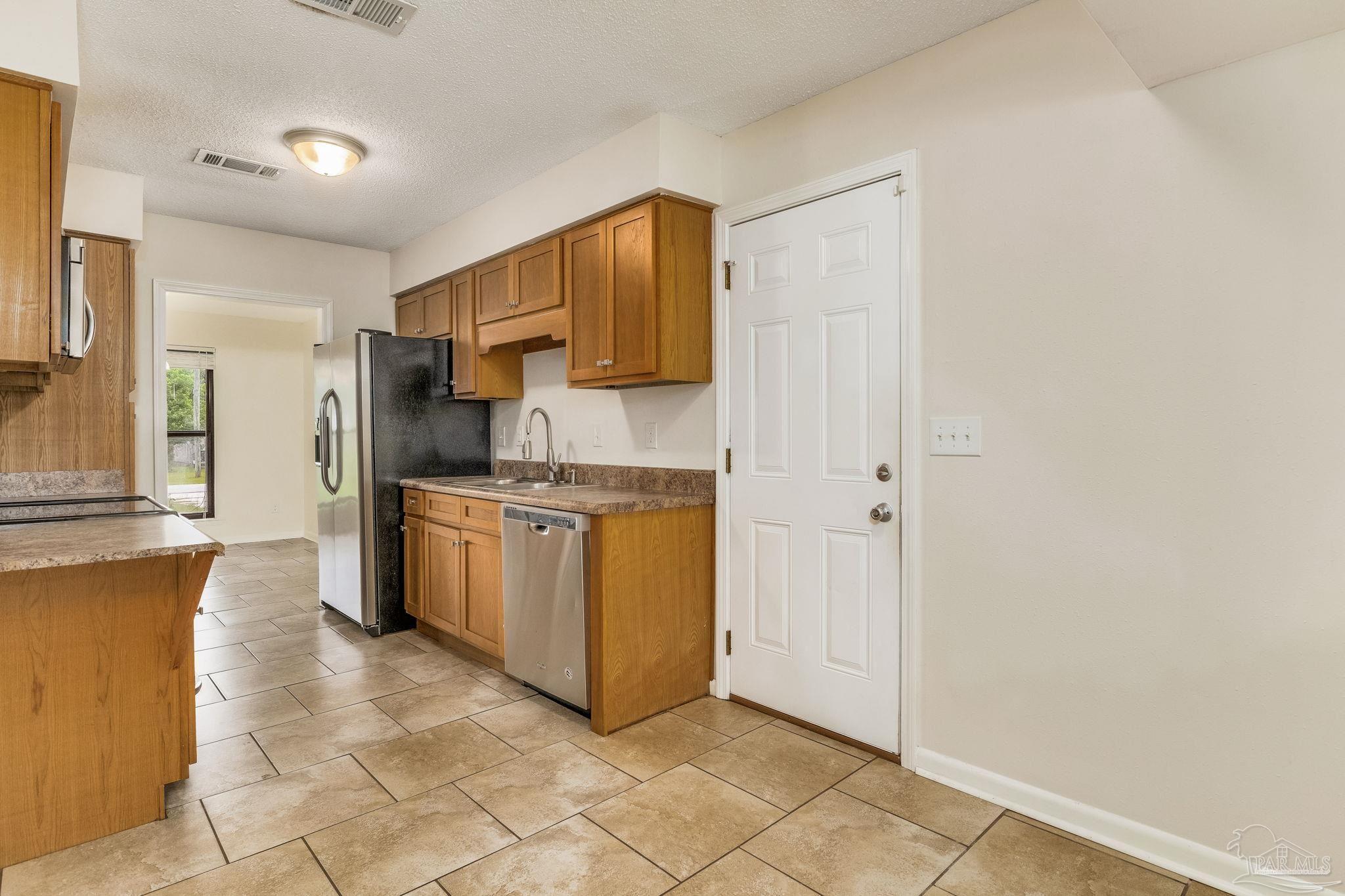 1422 Starlight Drive Cantonment, FL 32533 - Photo 12 of 49 a kitchen with a stove top oven and cabinets