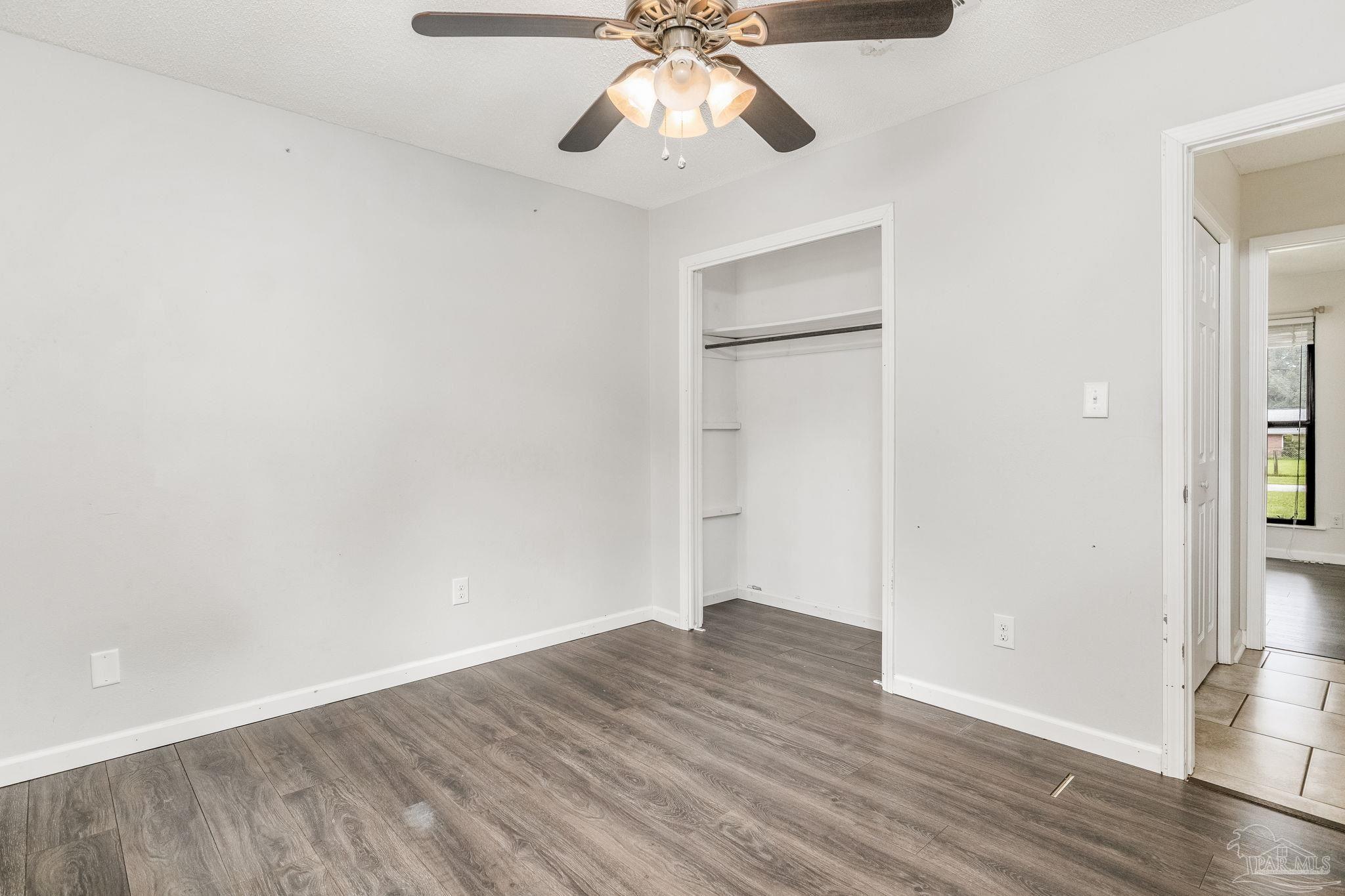 1422 Starlight Drive Cantonment, FL 32533 - Photo 23 of 49 a view of an empty room with wooden floor and a ceiling fan