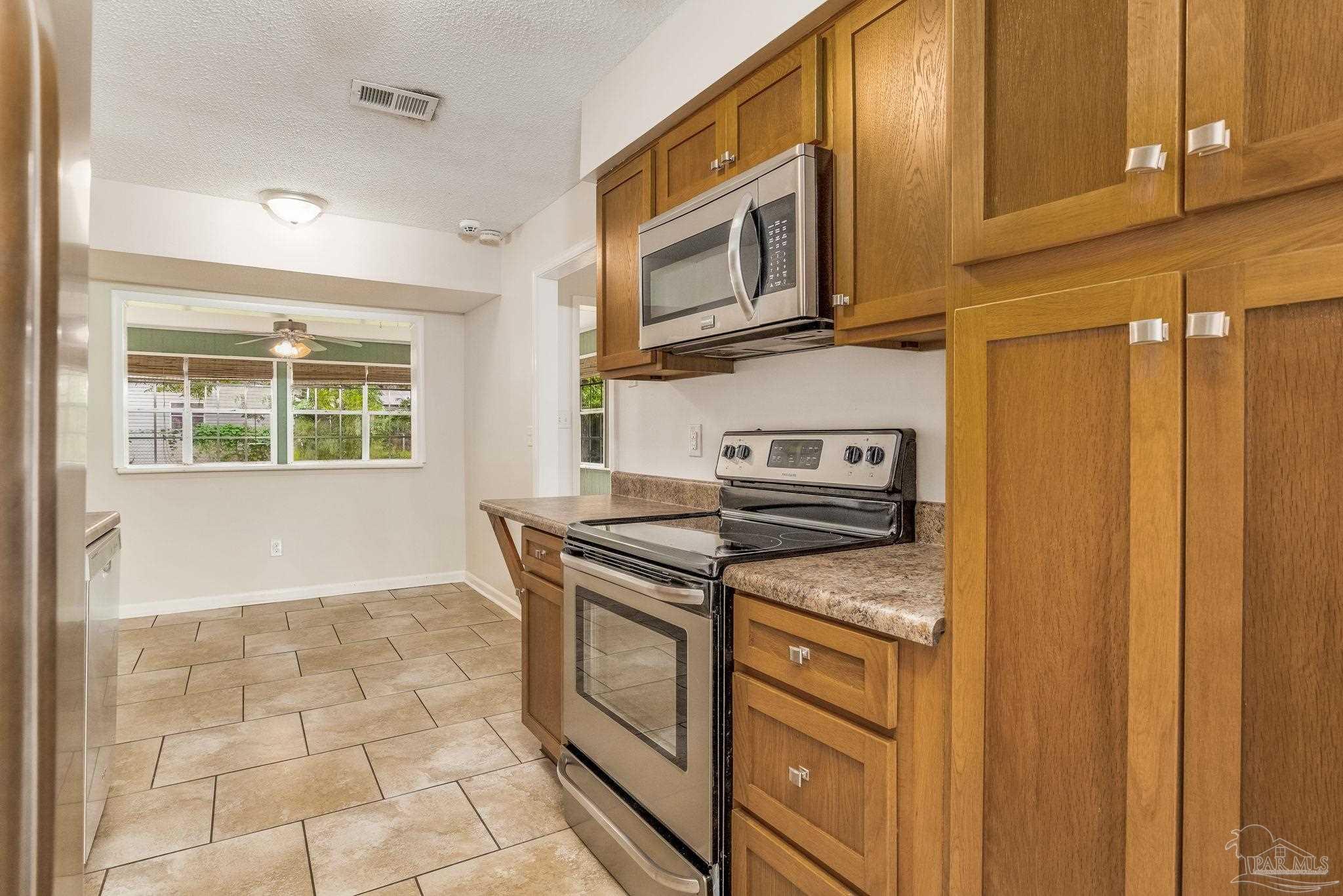1422 Starlight Drive Cantonment, FL 32533 - Photo 3 of 49 a kitchen with stainless steel appliances granite countertop a stove a microwave and a sink