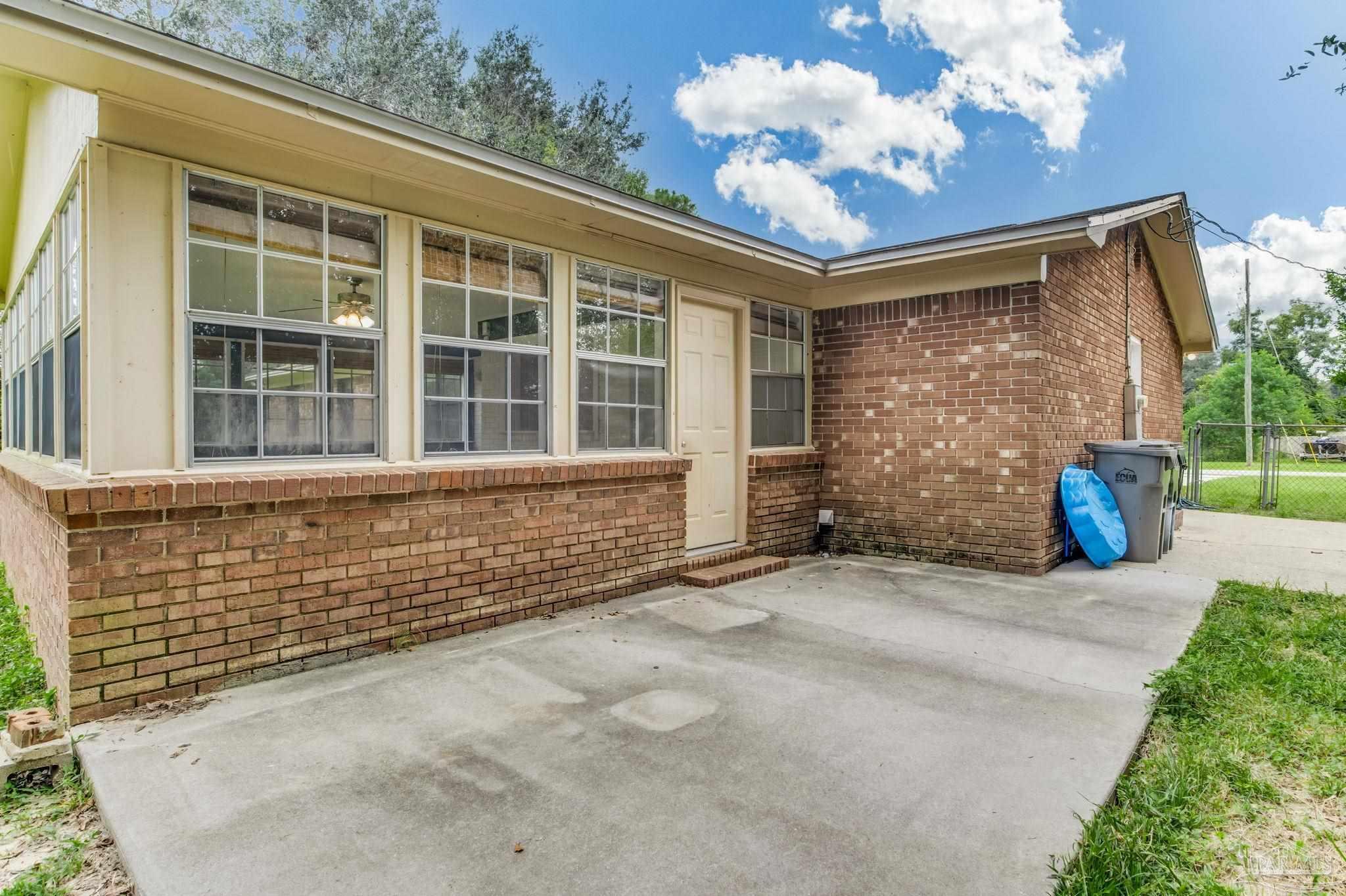1422 Starlight Drive Cantonment, FL 32533 - Photo 47 of 49 a front view of a house with a large window and potted plants