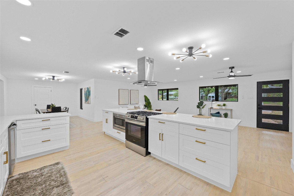 1305 Ridgehaven Drive Austin, TX 78723 - Photo 11 of 40 a large white kitchen with kitchen island a sink stainless steel appliances and cabinets