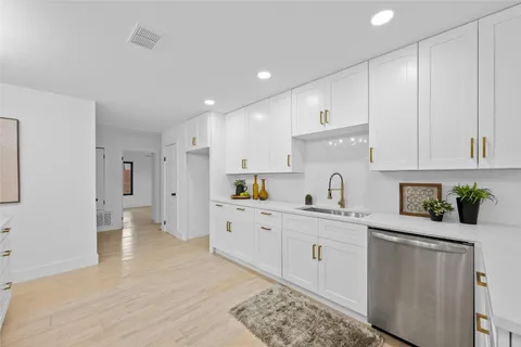 a kitchen with white cabinets and refrigerator