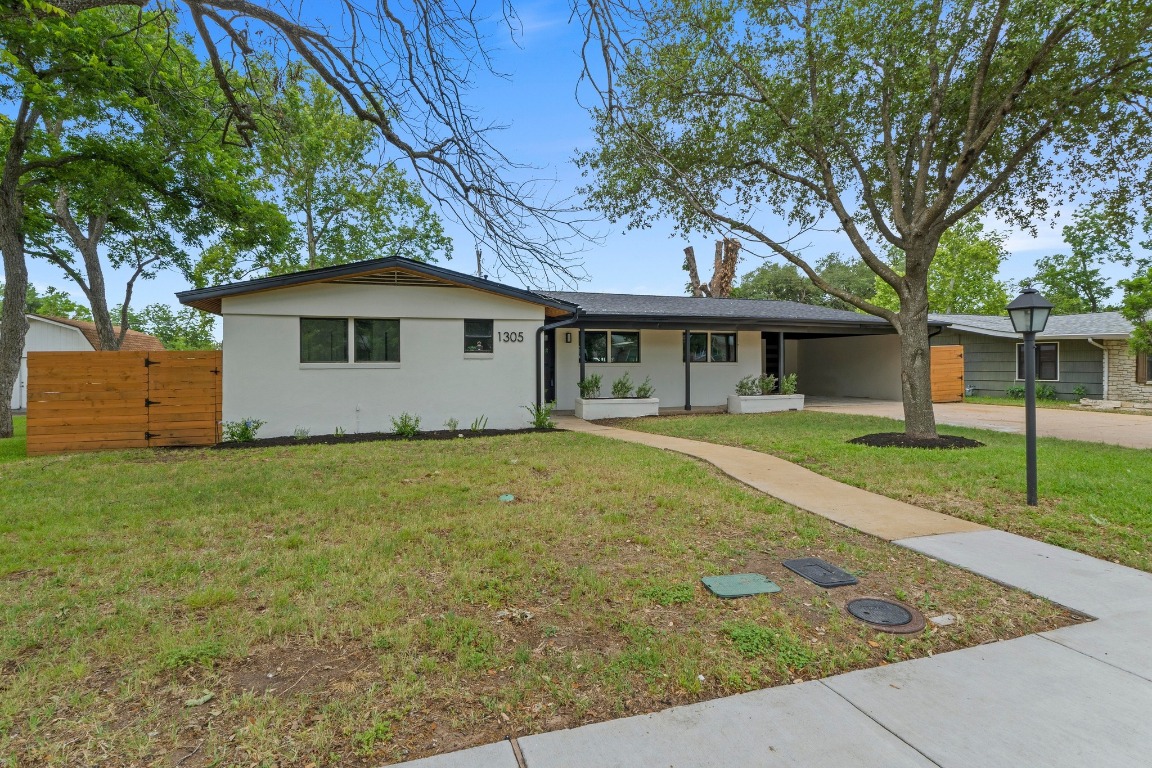 1305 Ridgehaven Drive Austin, TX 78723 - Photo 2 of 40 a view of a yard in front of a house with plants and large tree