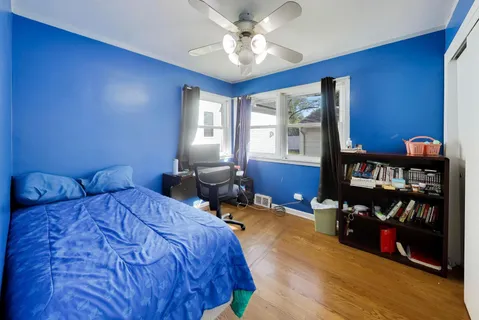 a bedroom with bed and wooden floor