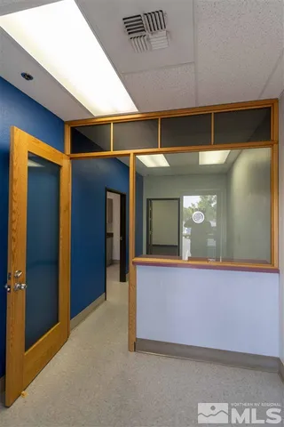 a view of an empty room with mirror and a sink