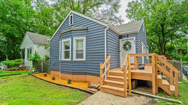a view of house with a yard and a large tree