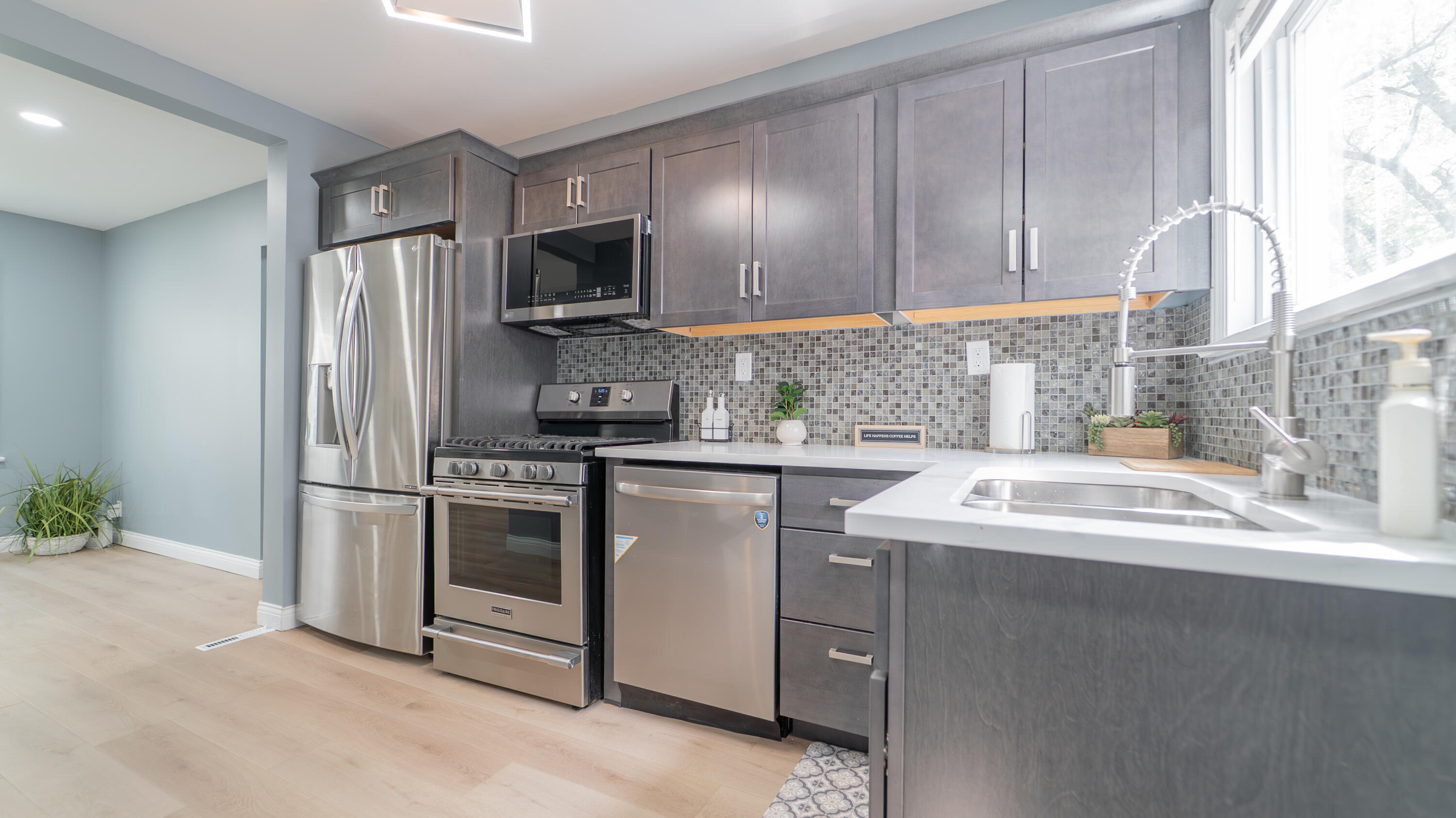 855 Fayette Street Gary, IN 46403 - Photo 8 of 25 a kitchen with stainless steel appliances granite countertop a sink a stove a refrigerator and a microwave