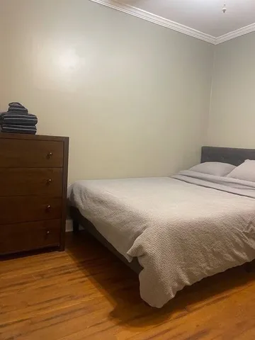 a bedroom with a bed and wooden floor