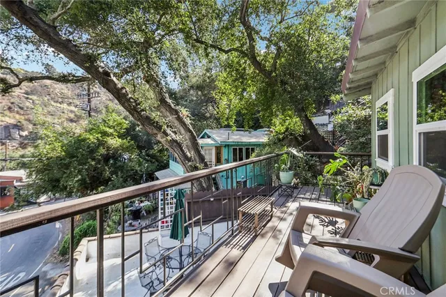 a balcony with wooden floor table and chairs
