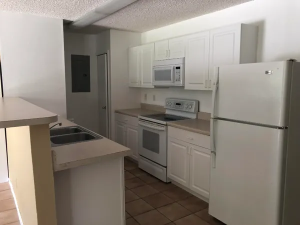 a kitchen with a stove sink and refrigerator