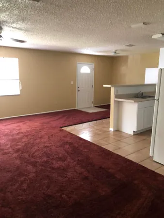 a view of a room with an empty space and wooden floor