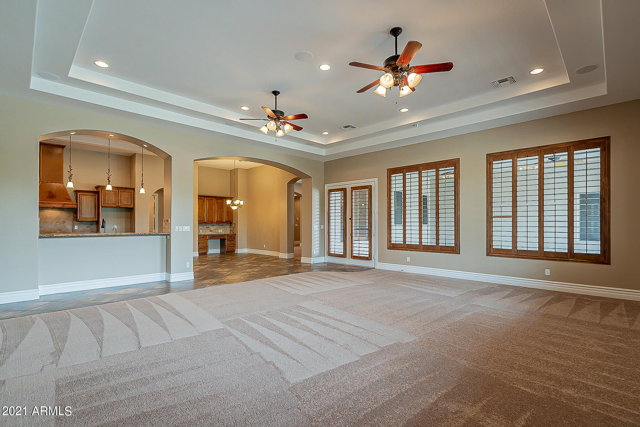 2789 East Ridgewood Lane Gilbert, AZ 85298 - Photo 21 of 60 a view of an livingroom with kitchen and chandelier fan