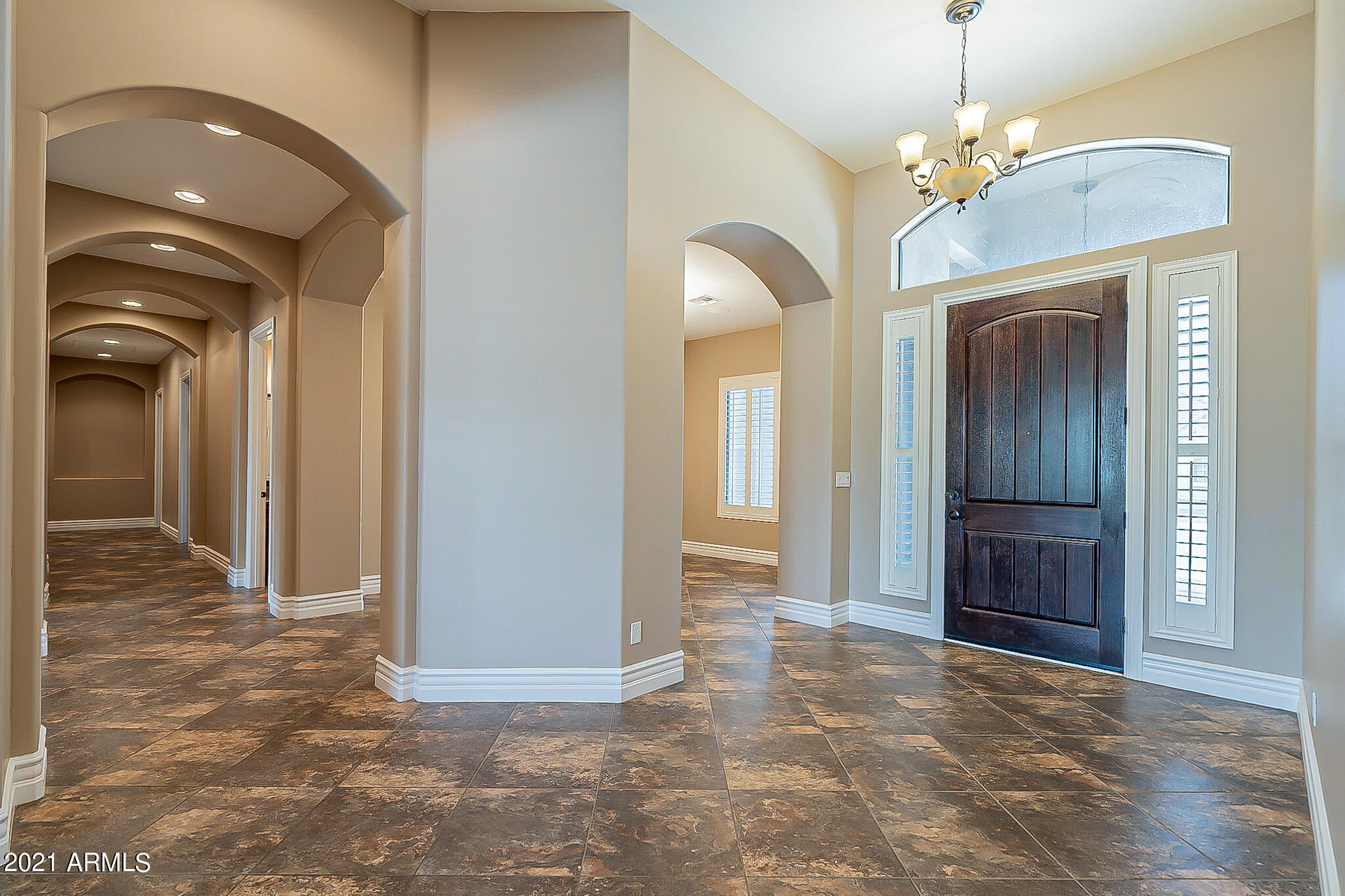 2789 East Ridgewood Lane Gilbert, AZ 85298 - Photo 4 of 60 a view of a hallway with wooden floor and a chandelier