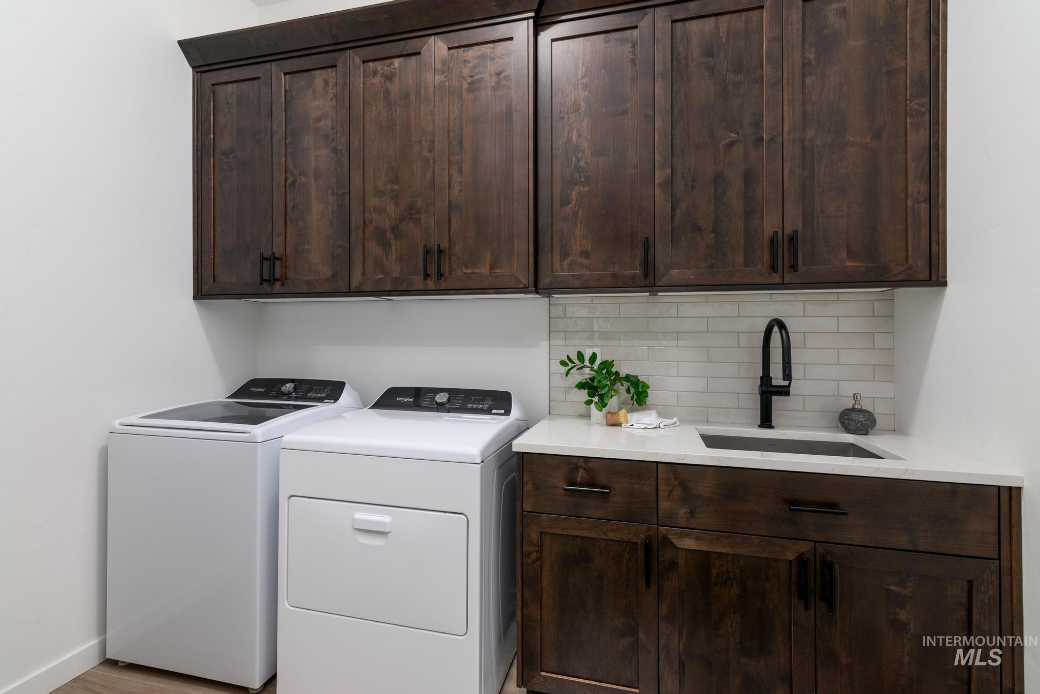 5410 Sparky Avenue Caldwell, ID 83607 - Photo 13 of 23 Washroom featuring washer and clothes dryer, cabinet space, and light wood-style floors