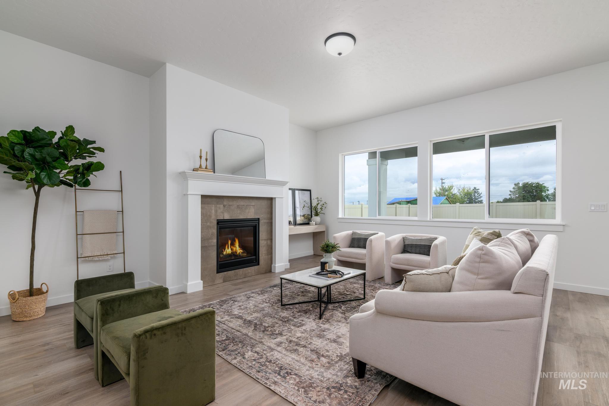 5410 Sparky Avenue Caldwell, ID 83607 - Photo 4 of 23 Living room with a tiled fireplace and light wood-style flooring