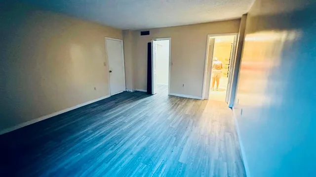 an empty room with wooden floor and a window