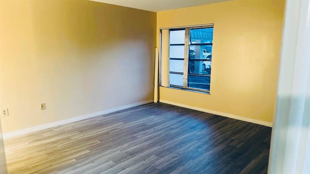 4170 Inverrary Drive, Unit 105 Lauderhill, FL 33319 - Photo 7 of 15 a view of an empty room with wooden floor and a window