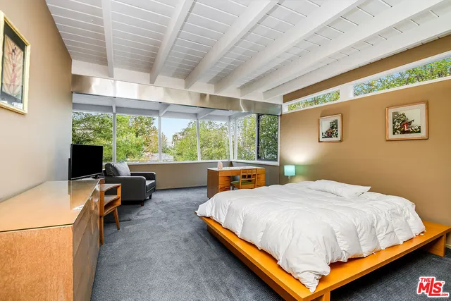 a bedroom with a bed and a large window