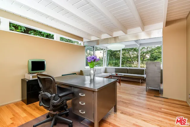 a view of a workspace with furniture and a window