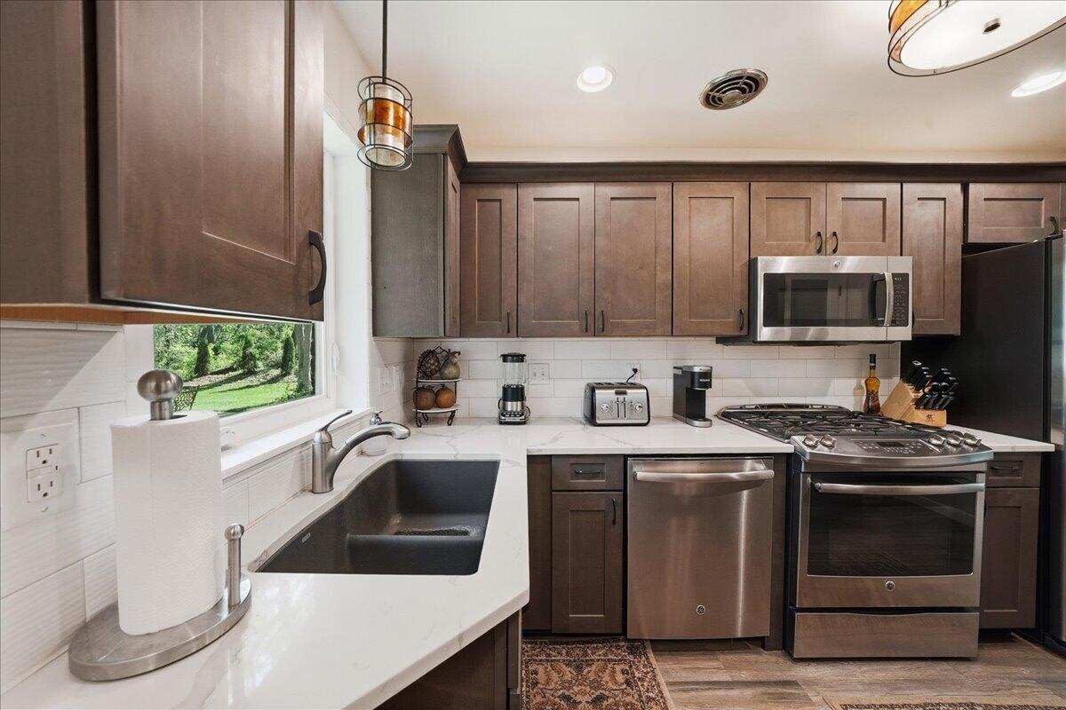 63 Ski Hill Road Portage, IN 46368 - Photo 4 of 28 a kitchen with stainless steel appliances a stove a sink and a microwave