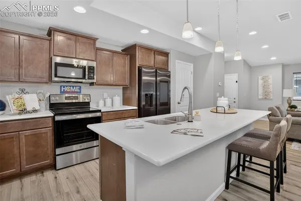 a kitchen with a stove a sink and a refrigerator