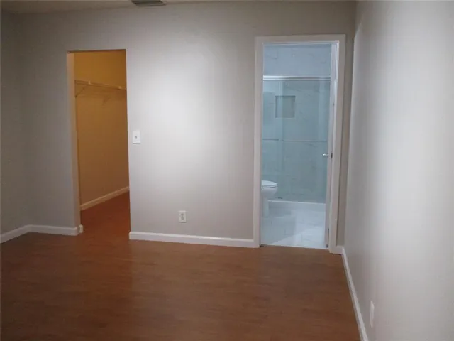an empty room with closet and mirror