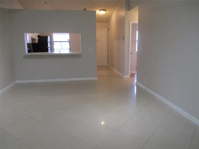 an empty room with windows and fireplace
