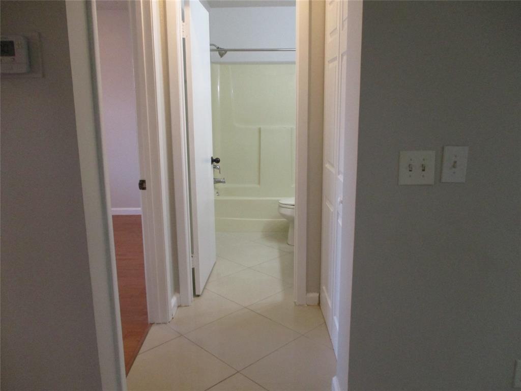 22052 Palms Way, Unit 205 Boca Raton, FL 33433 - Photo 15 of 28 a view of a bathroom from a hallway with toilet