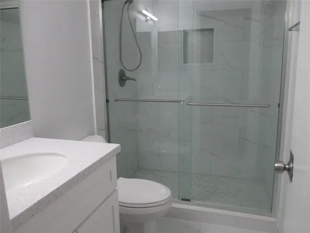 a bathroom with a shower a toilet and sink