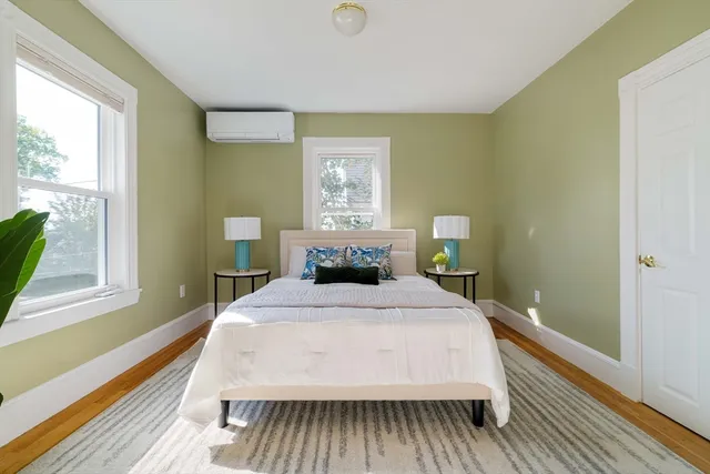 a bedroom with a bed lamp on table and a window