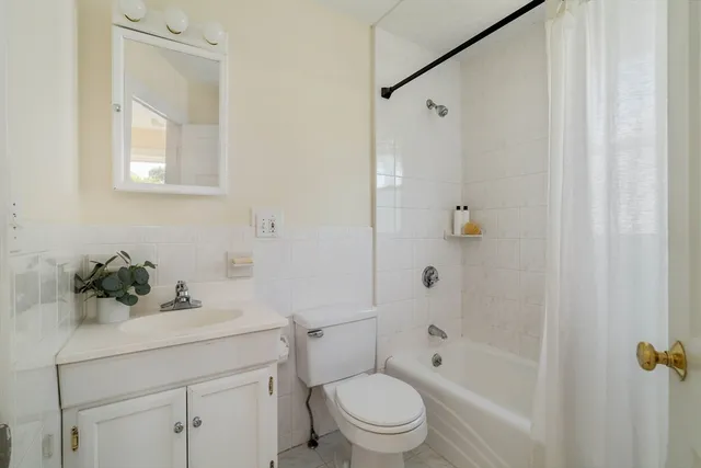 a bathroom with a sink a mirror a toilet and shower