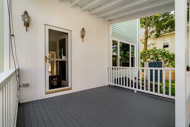 a view of a porch with wooden floor and a yard