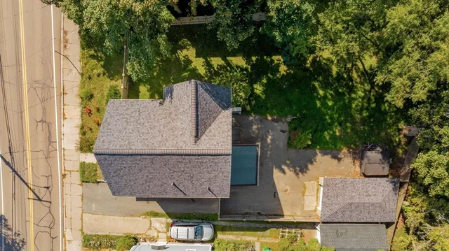 an aerial view of a house with a yard and large tree