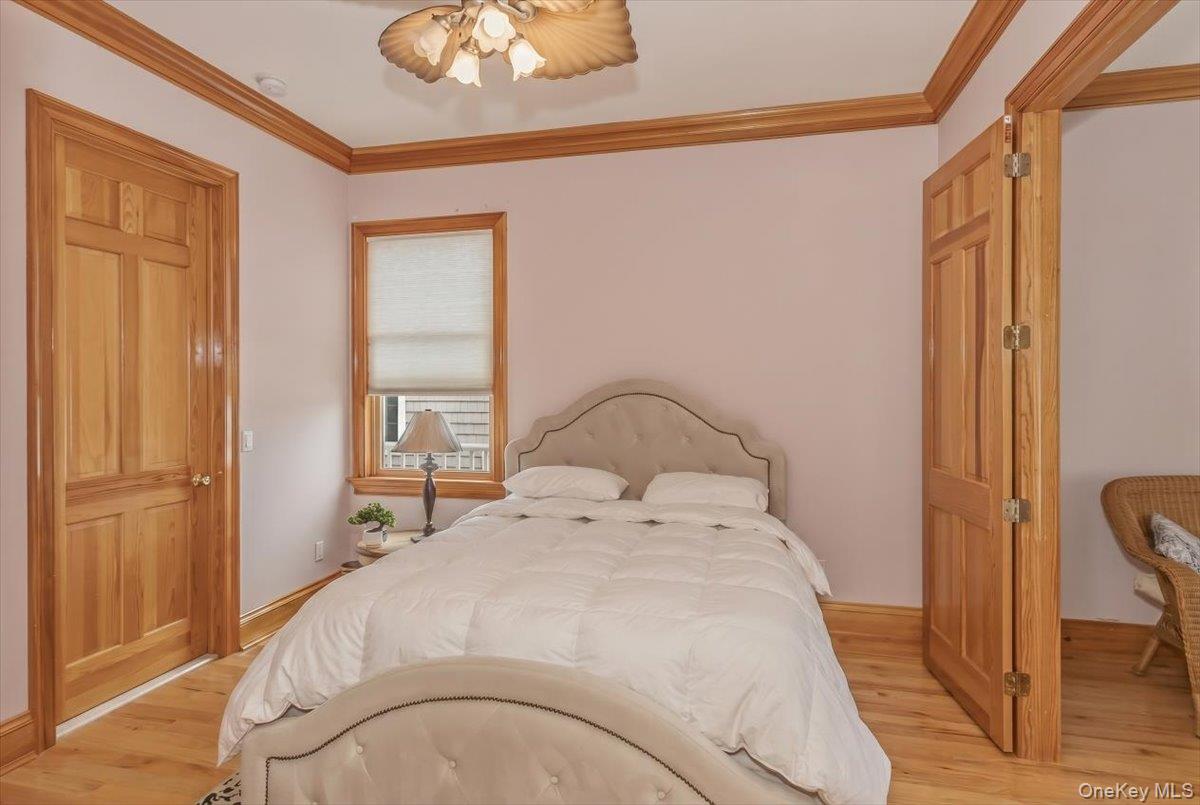 672 Dune Road Westhampton Beach, NY 11978 - Photo 17 of 38 a bedroom with a bed and a chandelier