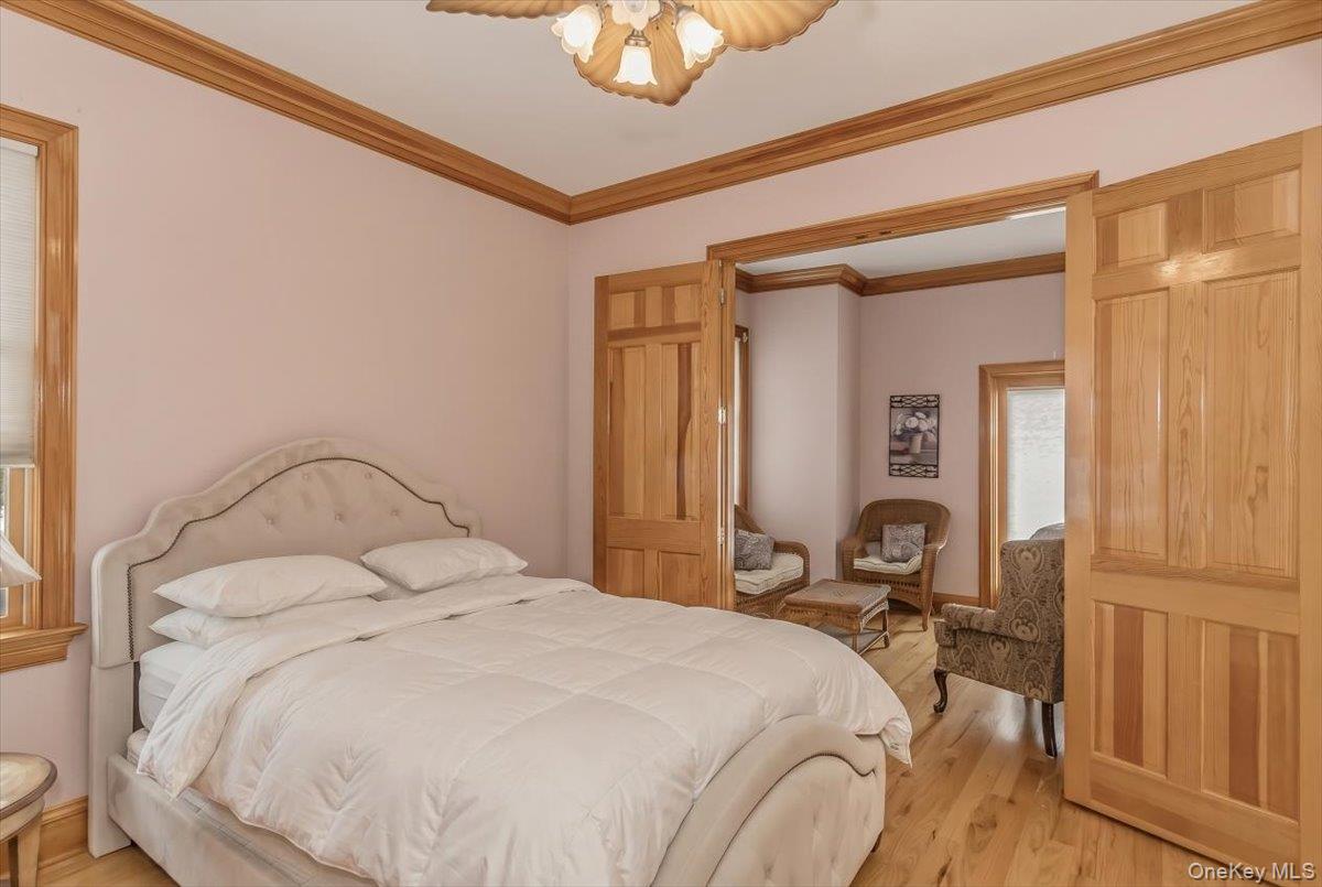 672 Dune Road Westhampton Beach, NY 11978 - Photo 18 of 38 a bedroom with a bed and a chandelier