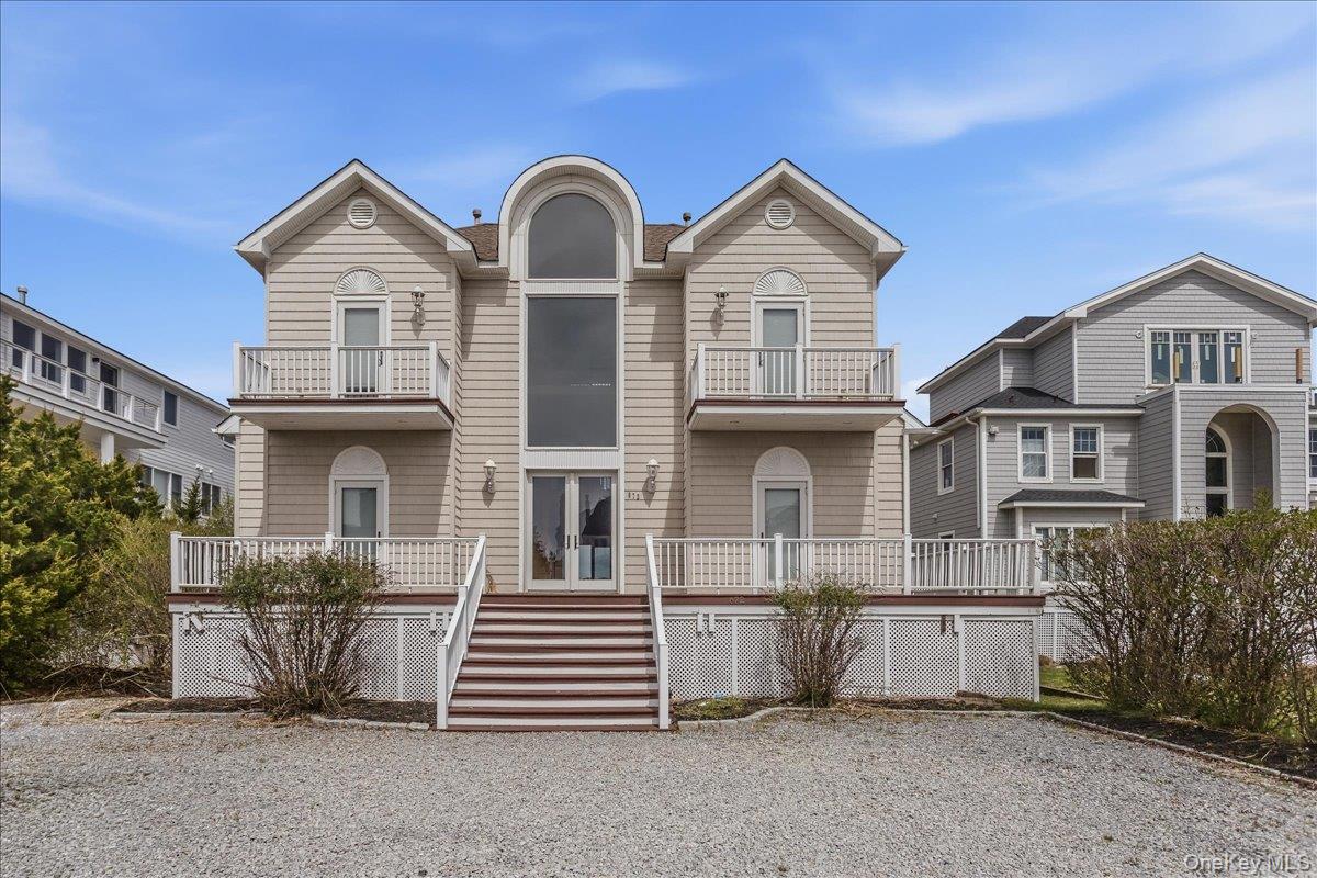 672 Dune Road Westhampton Beach, NY 11978 - Photo 2 of 38 a front view of a house with a yard