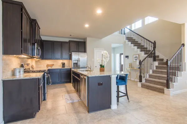 a kitchen with stainless steel appliances granite countertop a sink stove and microwave