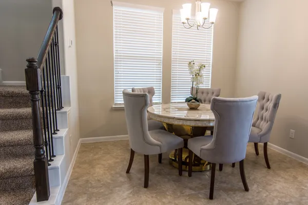 a open kitchen with stainless steel appliances kitchen island granite countertop a table and chairs in it