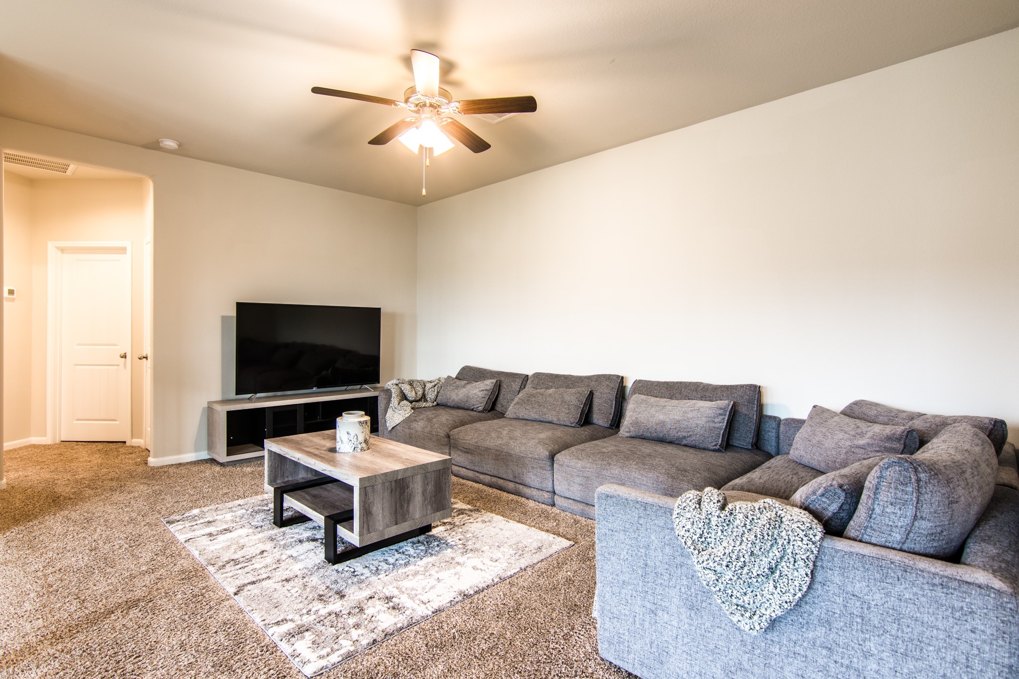 3311 Rainflower Springs Lane Rosenberg, TX 77471 - Photo 23 of 35 a living room with furniture a flat screen tv and a ceiling fan