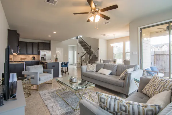 a living room with furniture kitchen view and a large window